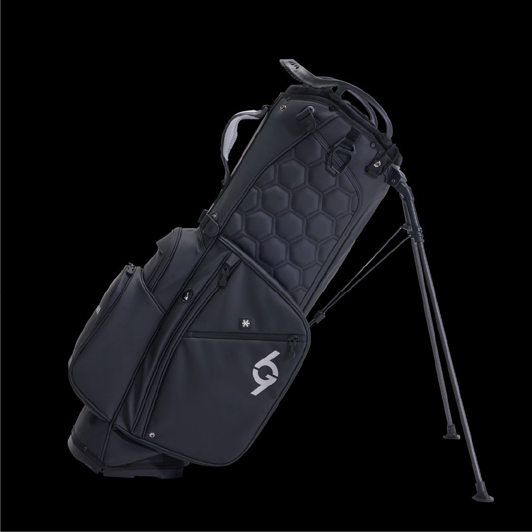 Black 69Golf stand bag with 14 dividers, hexagonal quilted pattern, dual straps, and metal legs extended.