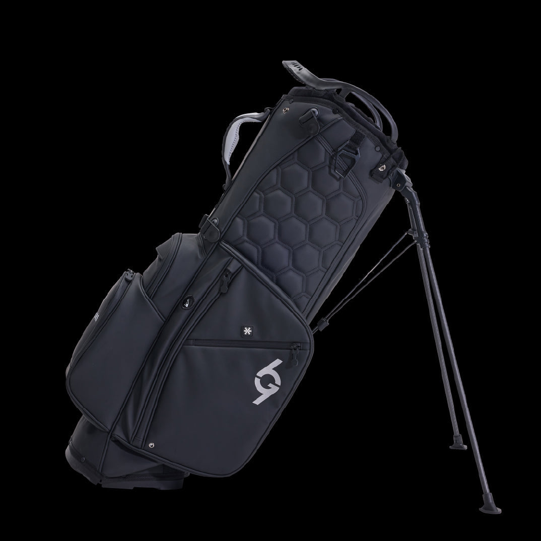 Black 69Golf stand bag with 14 dividers, hexagonal quilted pattern, dual straps, and metal legs extended.